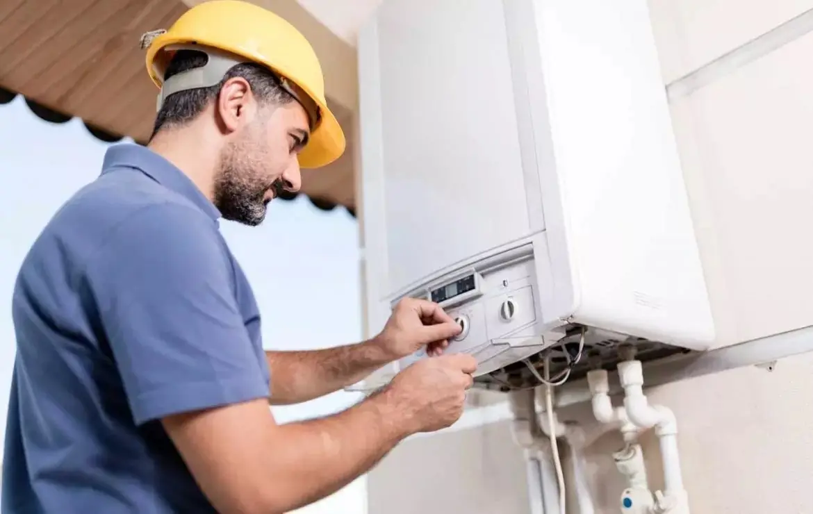 Técnico revisando un calentador de agua instalado en la pared
